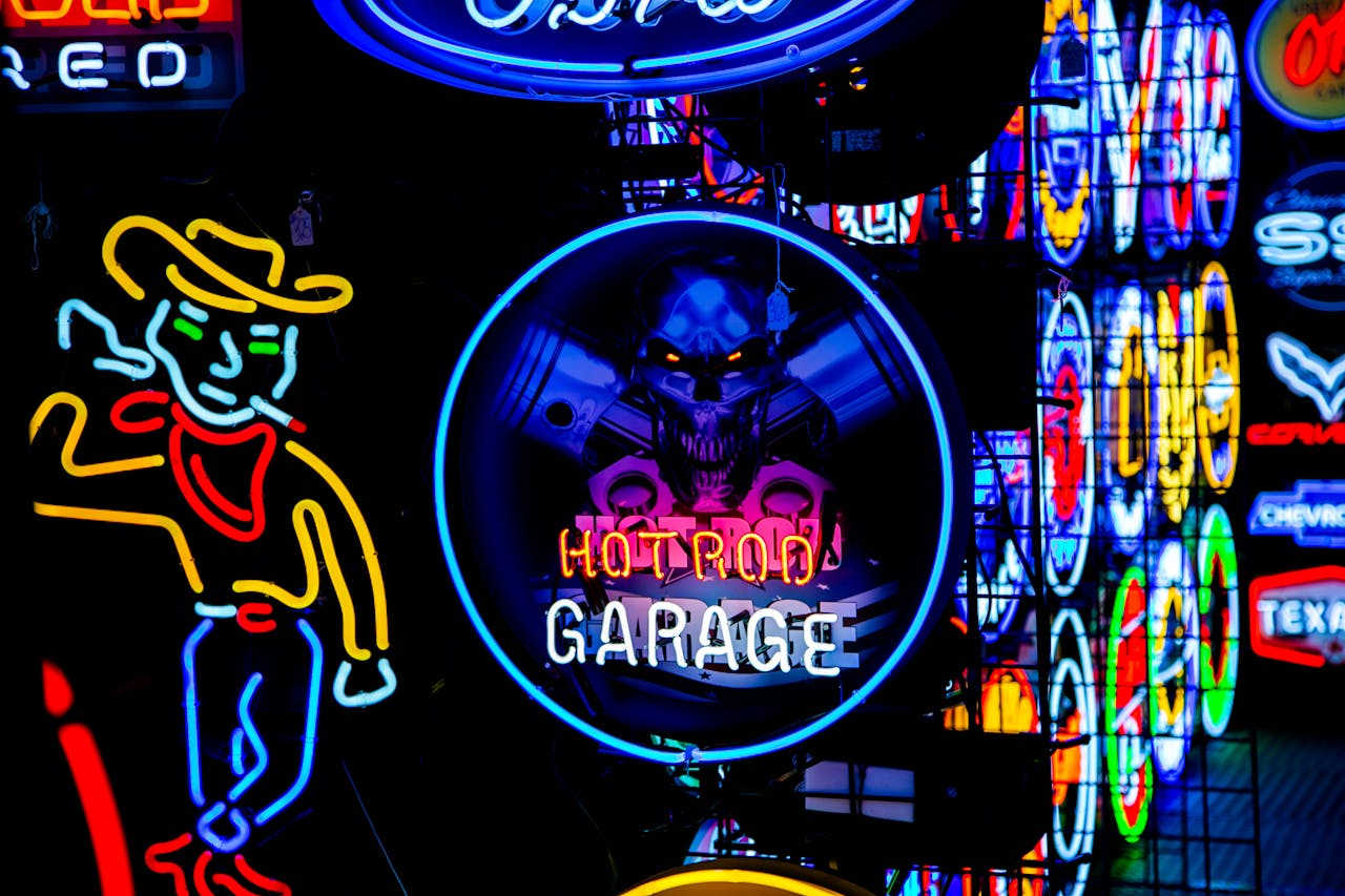 Services Bright neon signs including 'Hot Rod Garage' in a colorful night-time setting.